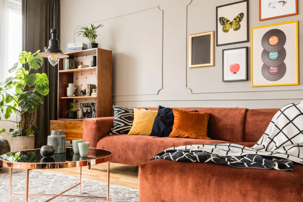 A modern living room with plants, furniture and a large orange couch