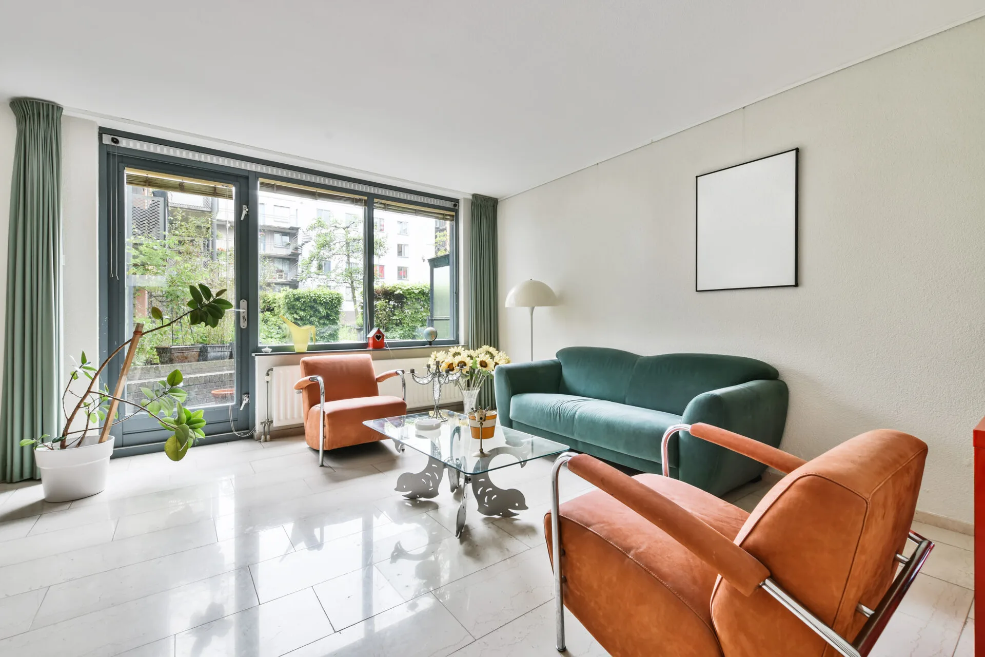 A modern living room with plants, furniture and a large green couch