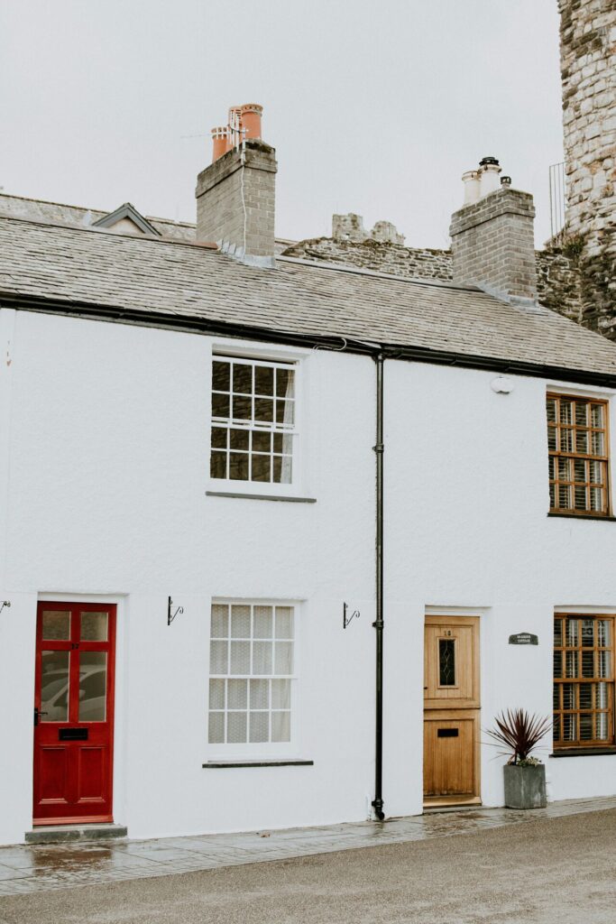 House fronts with a red door and brown door and picture windows